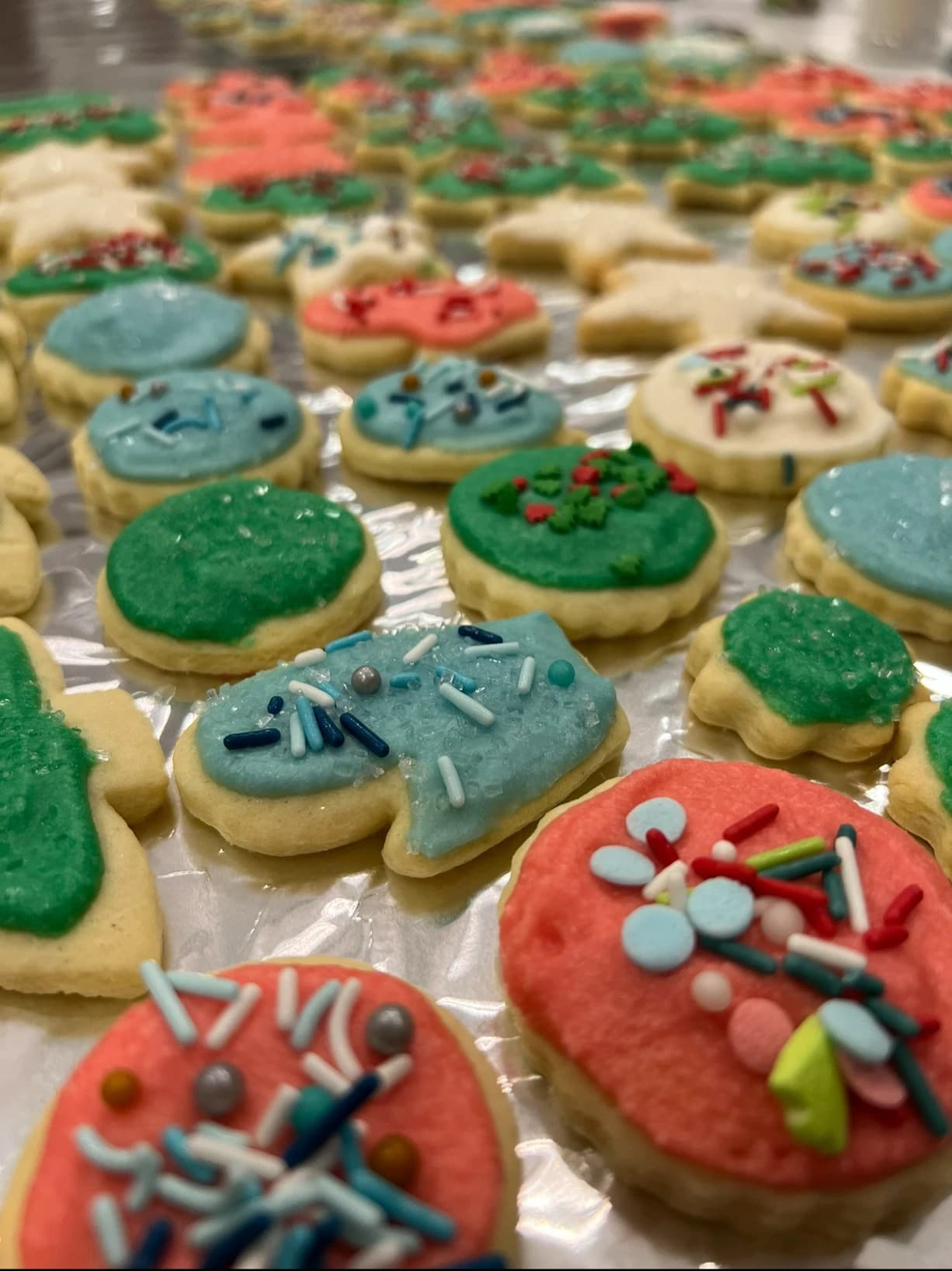 A colorful array of decorated holiday cookies with various icing and sprinkles.