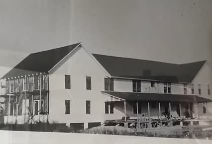 Black-and-white image of a partially constructed two-story building.