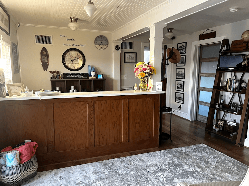 A cozy indoor space featuring a wooden counter, decorative flowers, and framed pictures on the walls.