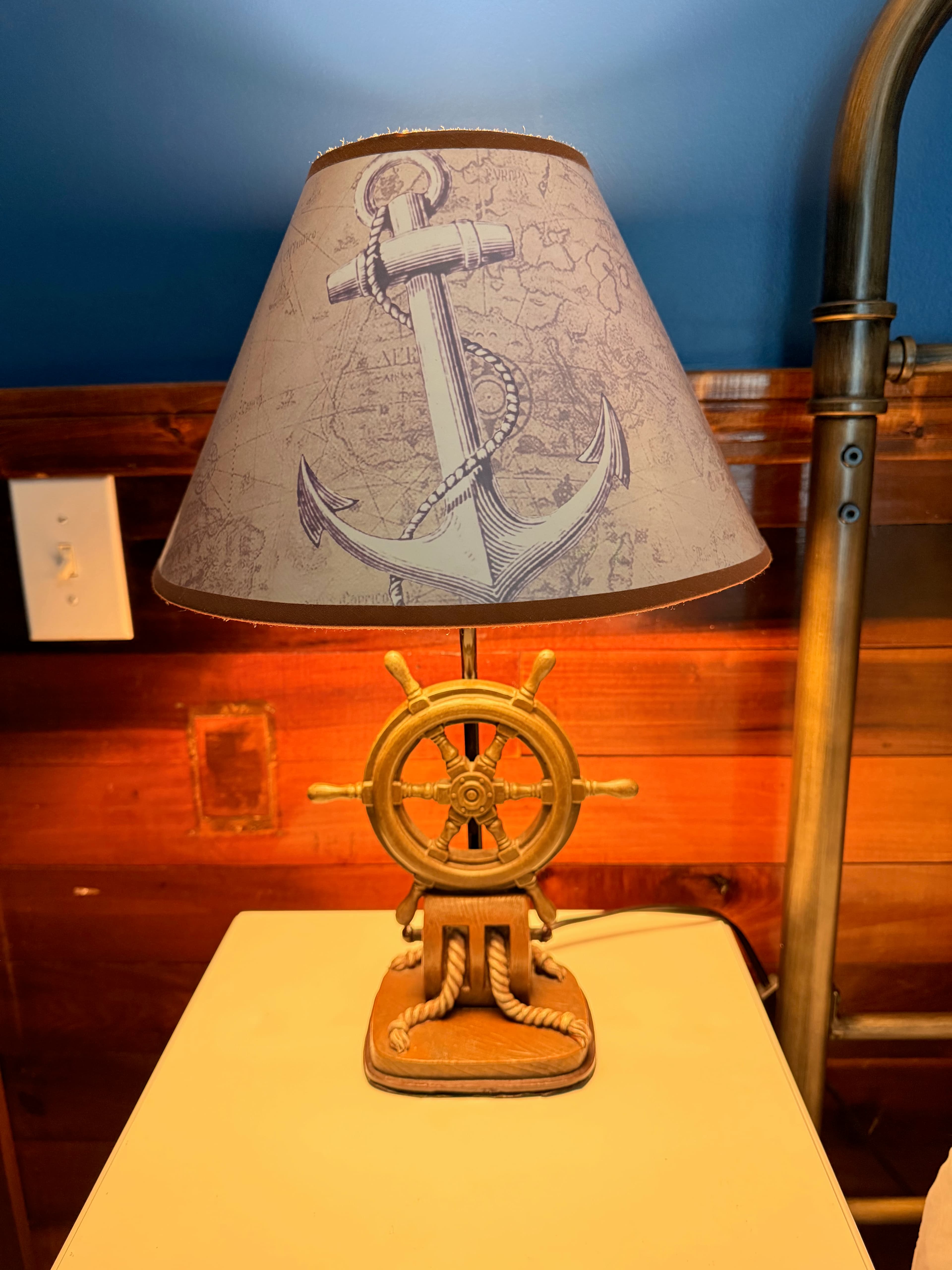 Nautical lamp beside a bed