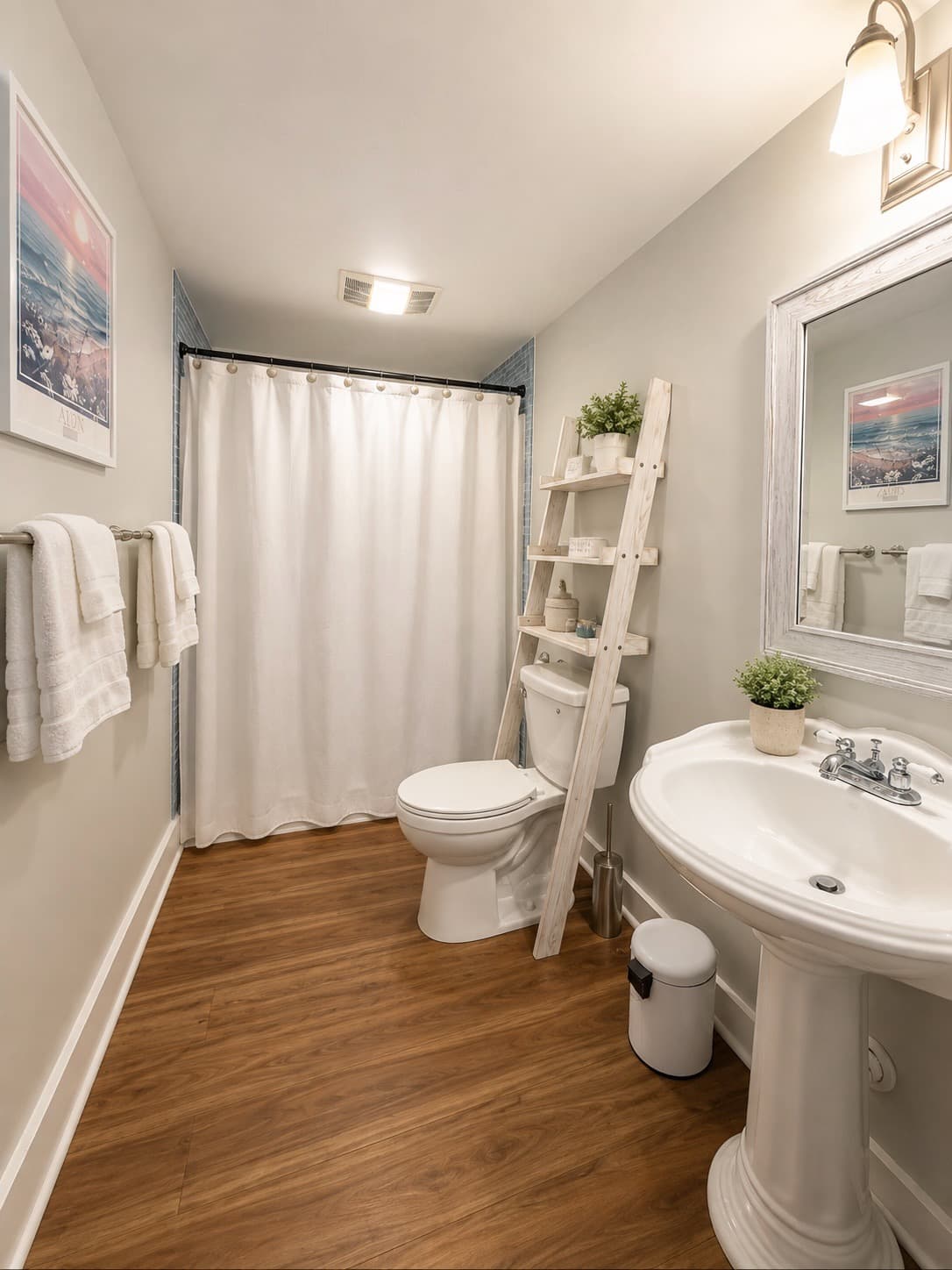 A clean, modern bathroom featuring a shower curtain, toilet, and sink with wooden flooring.